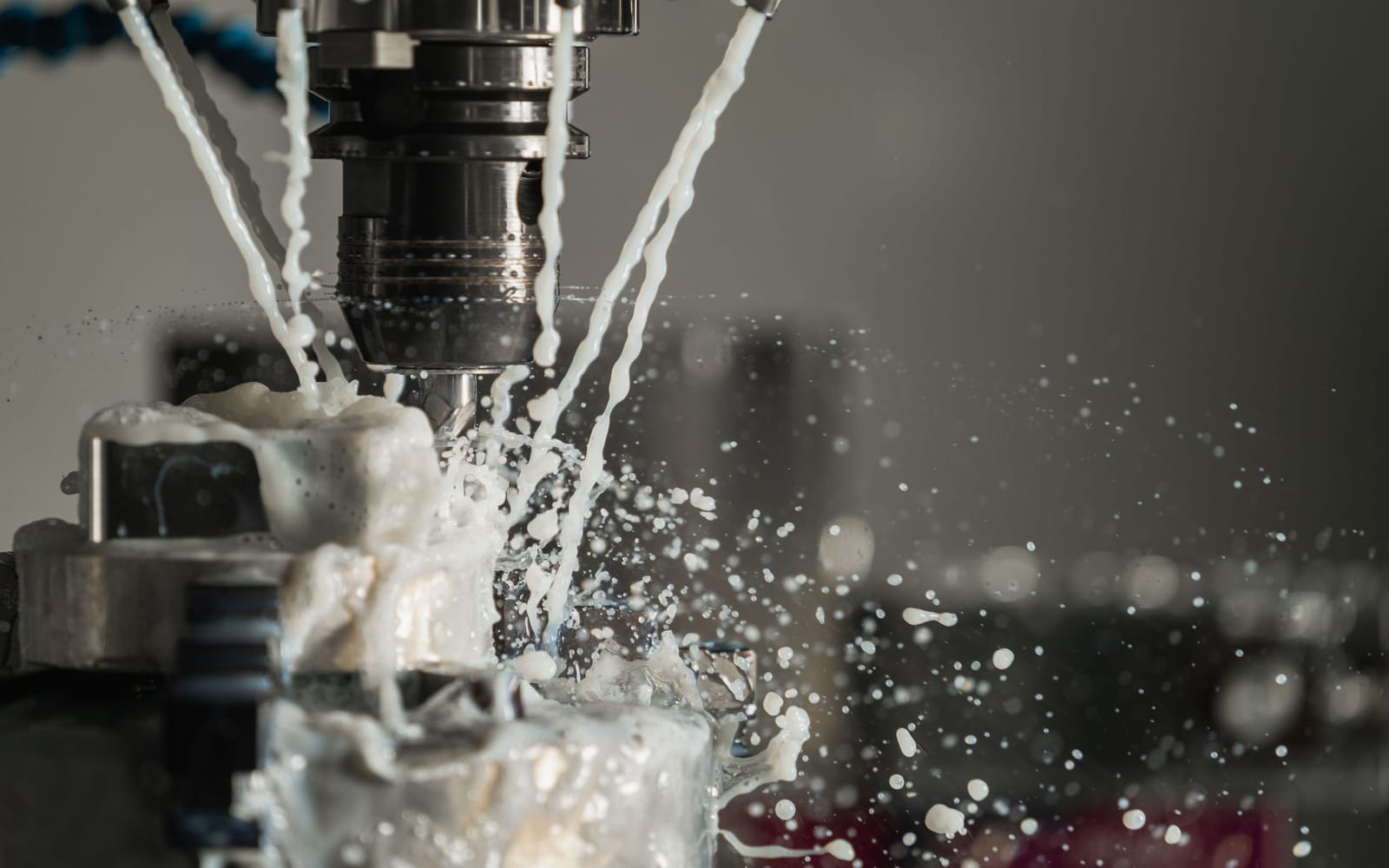 Frässpindel einer CNC-Maschine bei der Metallbearbeitung mit spritzendem Kühlschmierstoff