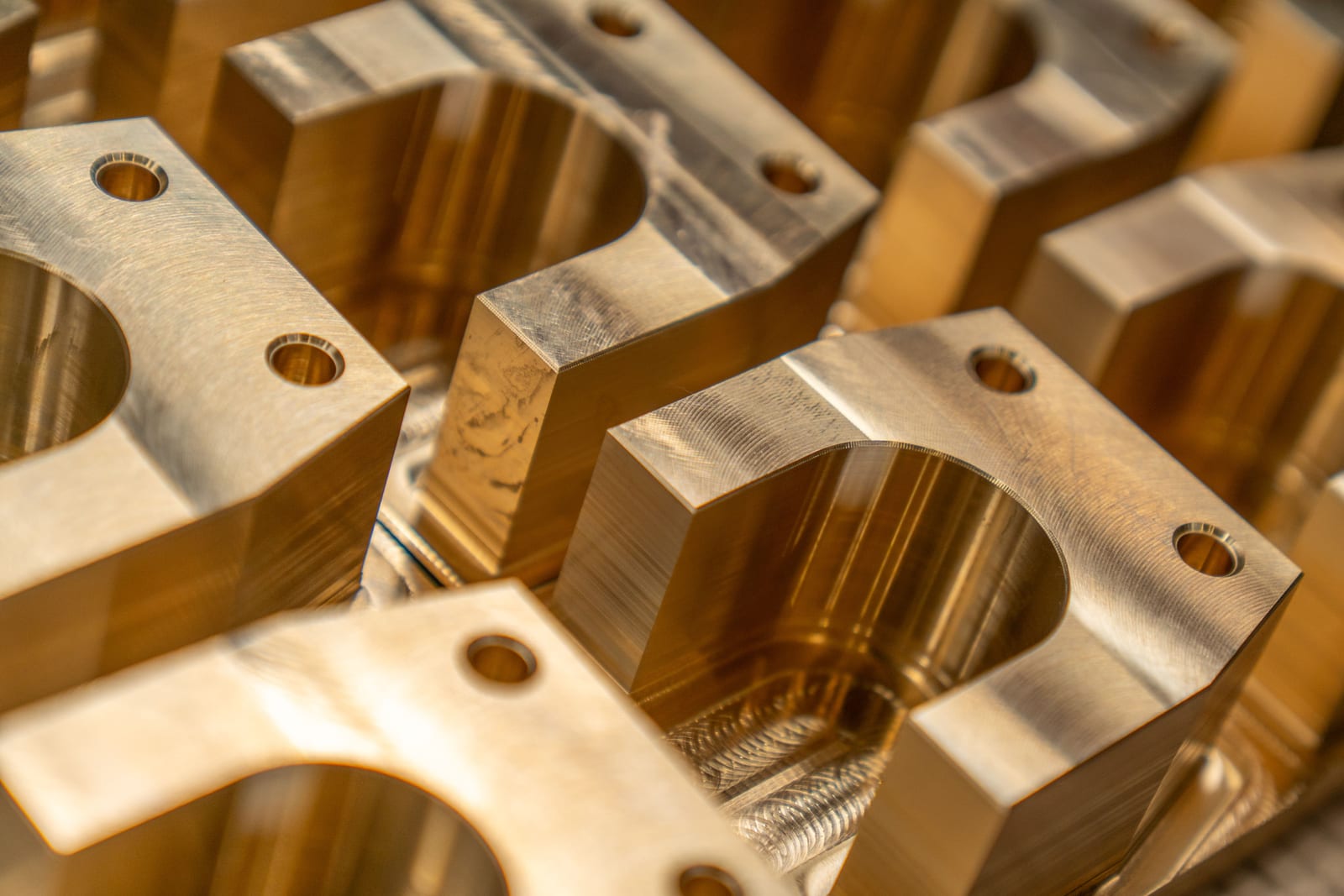 Nahaufnahme CNC-gefräster Messing-Bauteile mit ausgefrästen Rundtaschen und Bohrungen