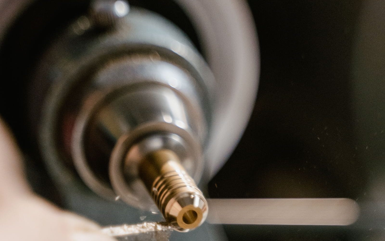 Gedrehtes Messingteil mit Einstichen in der Spindel einer Drehmaschine