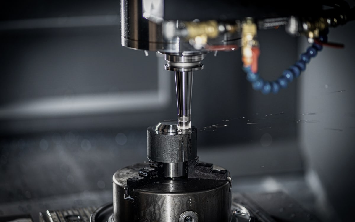 CNC-Bearbeitung eines Stahlbauteils in dunkler Maschinenumgebung